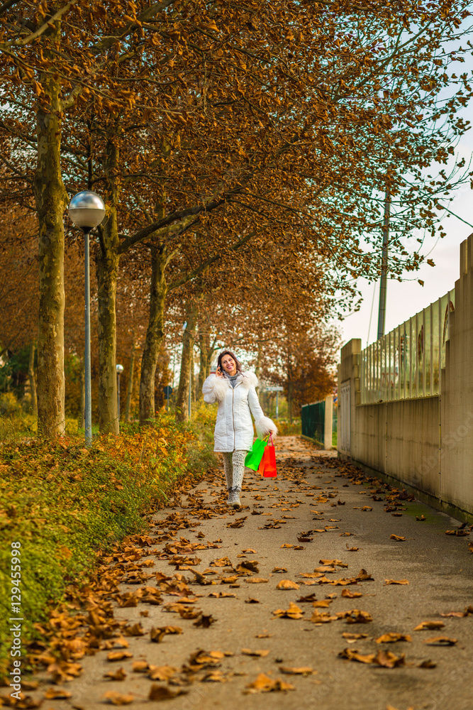 Fototapeta premium woman talking on phone with shopping bags
