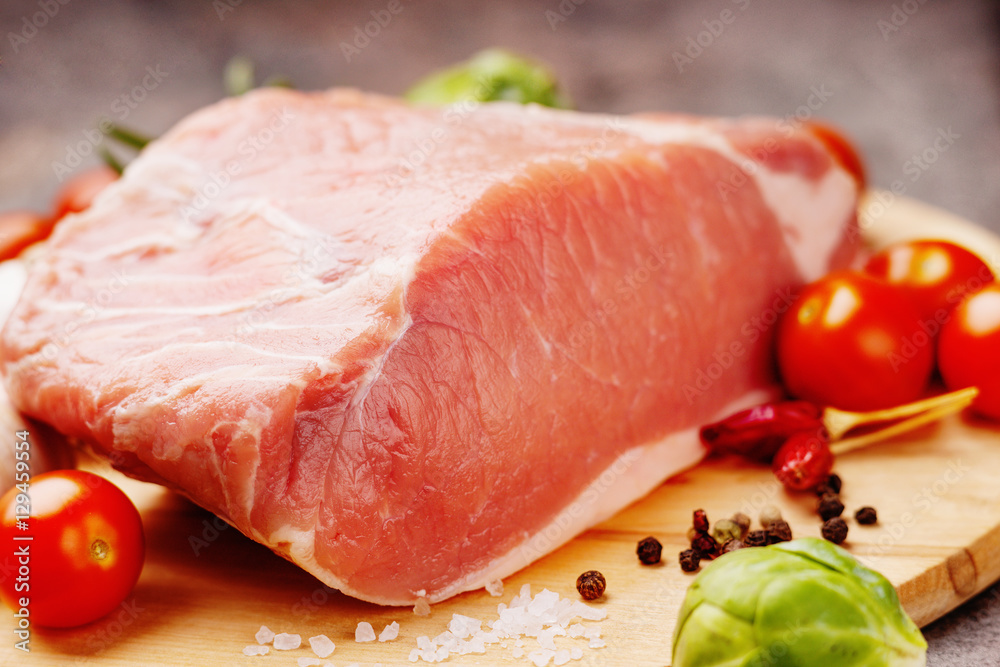 Raw pork on cutting board and vegetables Raw pork on cutting board and vegetables