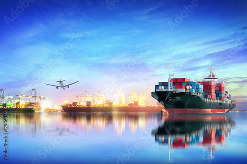 Logistics and transportation of international container cargo ship and cargo plane with ports crane bridge in harbor at sunset sky for logistics import export background and transport industry. photo