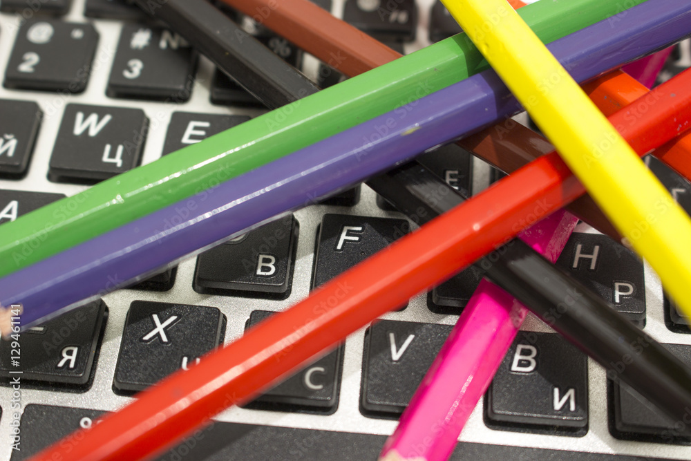 Цветные карандаши рассыпаны на клавиатуре