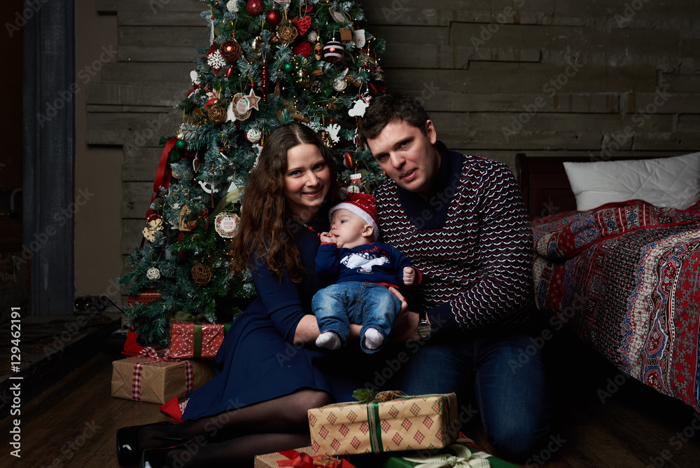 Happy caucasian family posing in studio with christmas tree