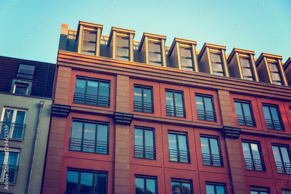 Fototapeta premium red facaded building with big blue windows