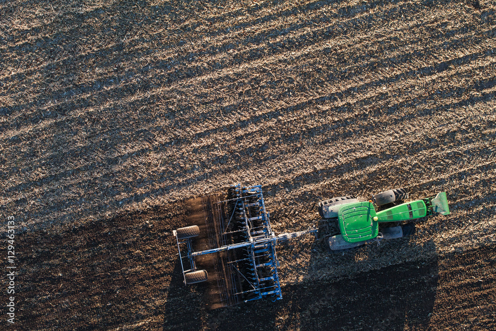 Naklejka premium aerial view of harvest fields with tractor in Poland
