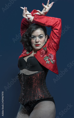 Spanish flamenco dancer with bow in hair and red coat with neutr photo