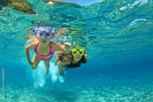 Happy family - mother with baby girl dive underwater with fun in sea pool. Healthy lifestyle, active parent, people water sport outdoor adventure, swimming lessons on beach summer holidays with child