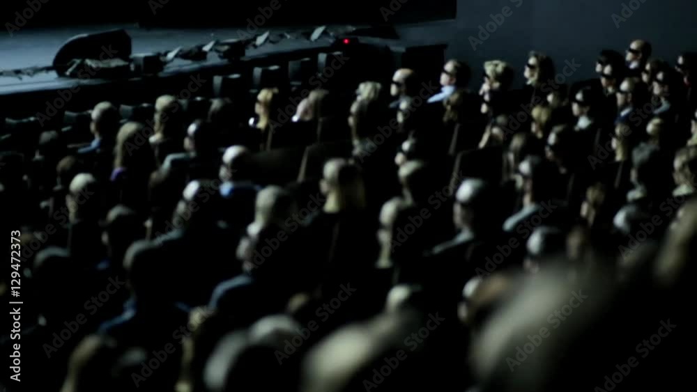 Group of people in 3D glasses watching movie in cinema