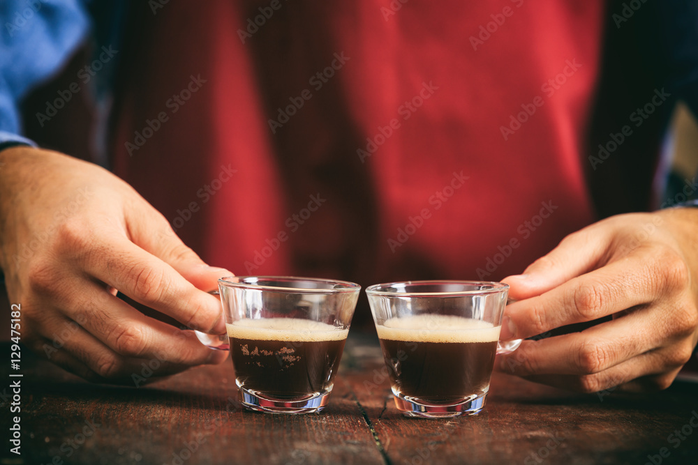 Barista holding two espresso cups