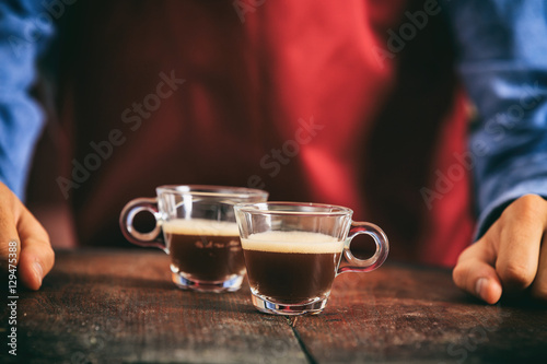 Barista holding two espresso cups