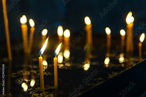 Long lighted church candles against a dark background