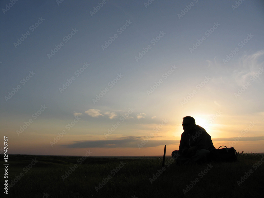 A man sits on a sunset