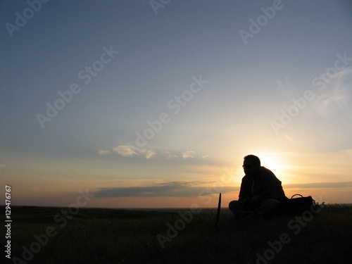 A man sits on a sunset