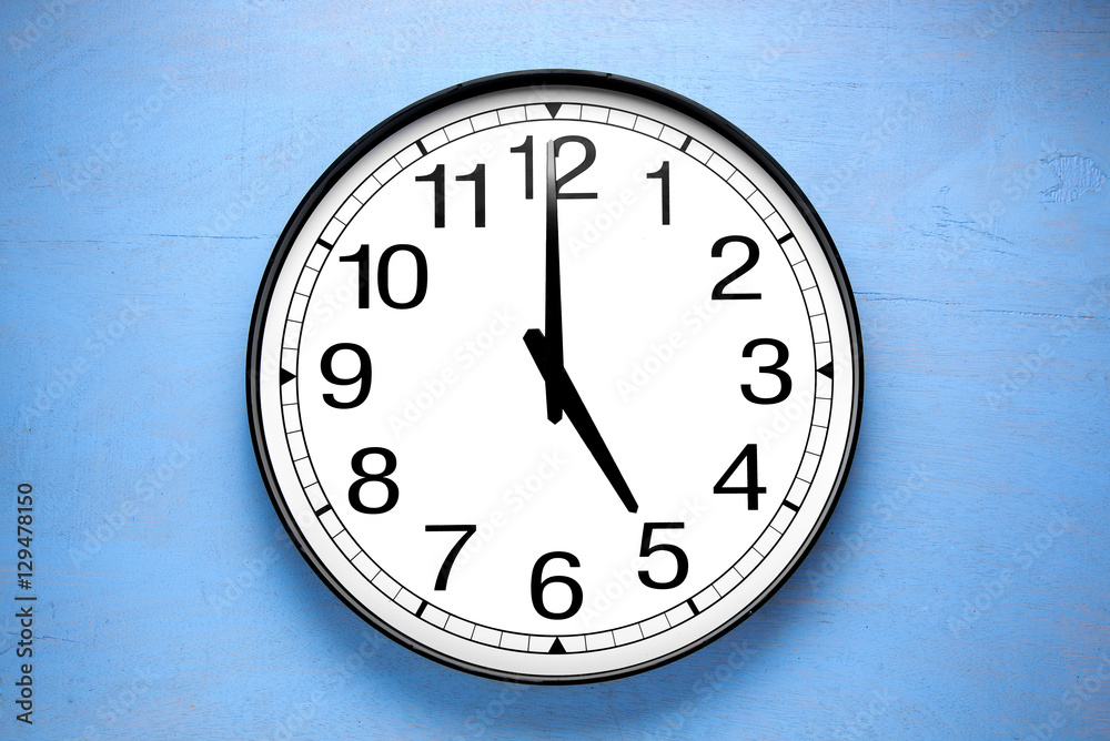 Round clock shows shows at 5 o'clock, clock on blue background Round clock shows shows at 5 o'clock, clock on blue background