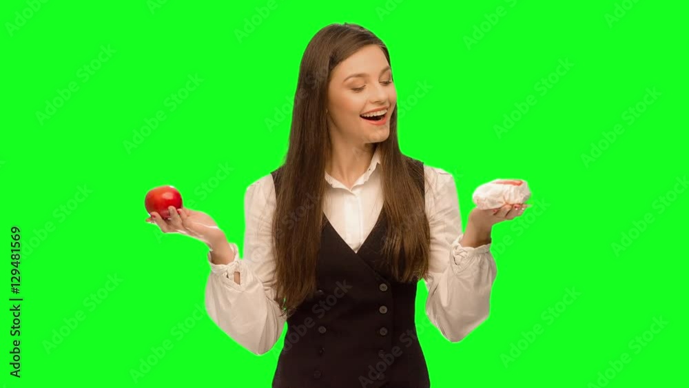 Woman choosing to eat burger instead of apple Woman choosing to eat burger instead of apple