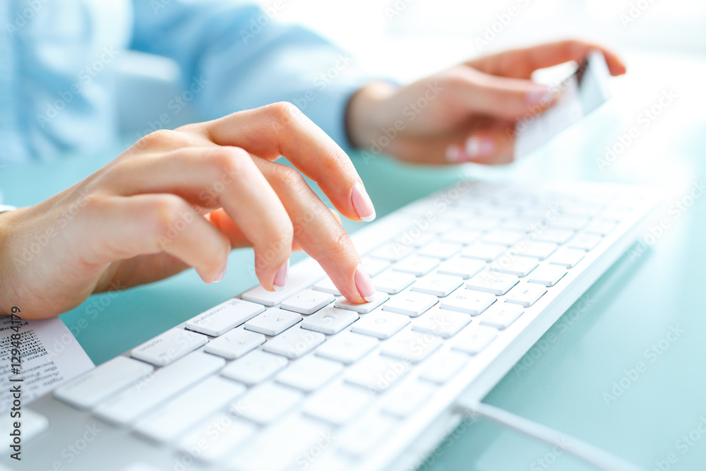 Hands using computer and credit card Hands using computer and credit card