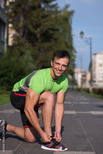 Young athlete, runner tie shoelaces in shoes