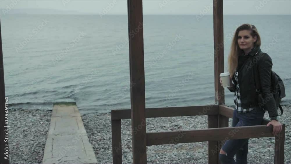 Cute young pretty woman drinking coffee on the beach sea shore slow motion Cute young pretty woman drinking coffee on the beach sea shore slow motion