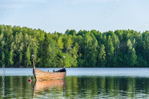 Birds on a fishing boat on a green peaceful forest lake