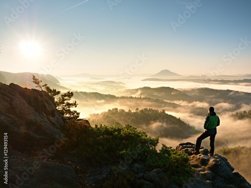 Man silhouette stay on sharp rock peak. Satisfy hiker enjoy view. © rdonar