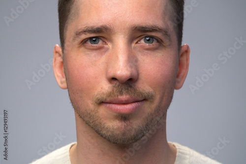 Close up smiling man's face, gray background