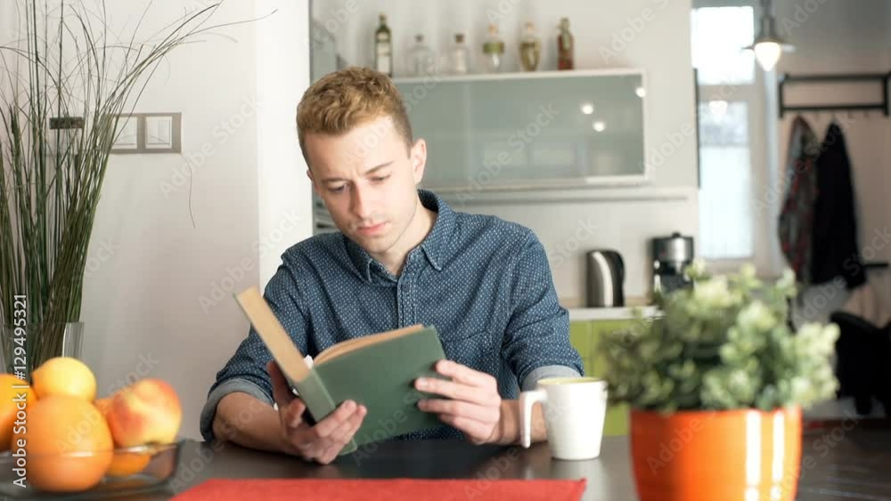 Happy, red haired man reading book and smiling to the camera
Happy, red haired man reading book and smiling to the camera