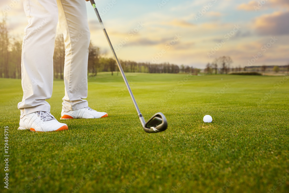 Obraz premium Golf ball on grass in front of golf club