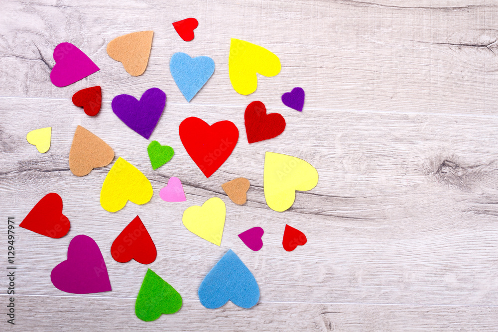 Obraz premium Bunch of multicolored hearts. Colorful hearts on wooden surface. Romantic surprise on a table. Magic of colours.