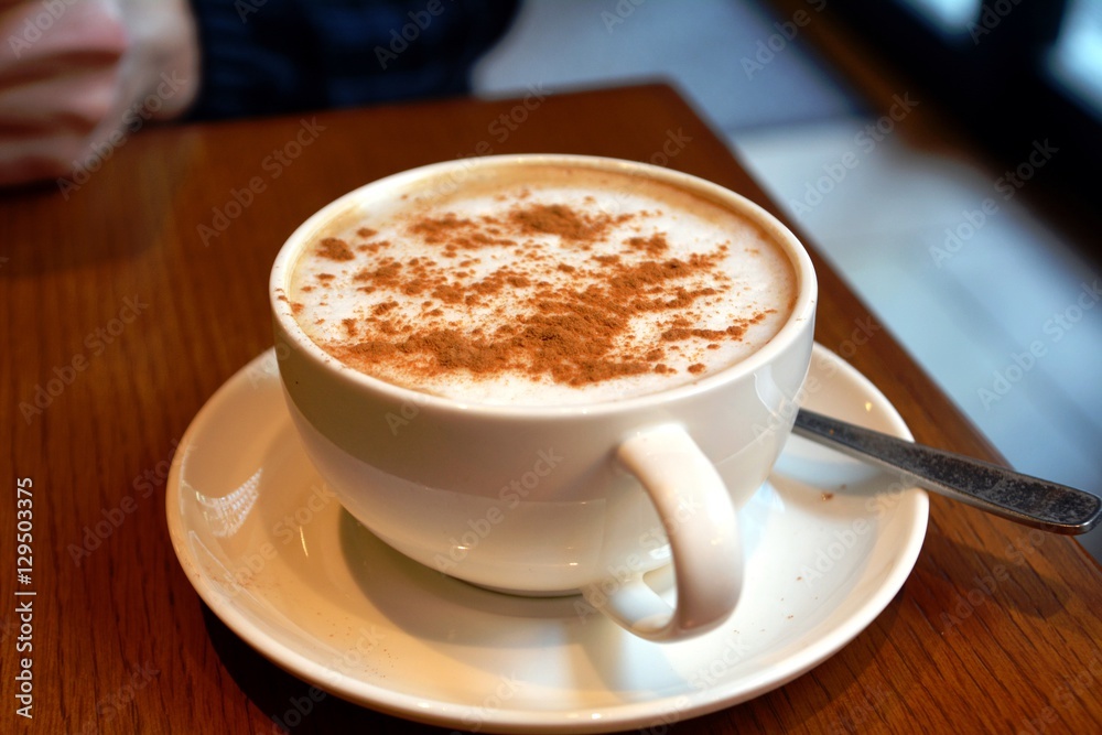 Cup of foamy cappuccino on a wooden table. Cup of foamy cappuccino on a wooden table.