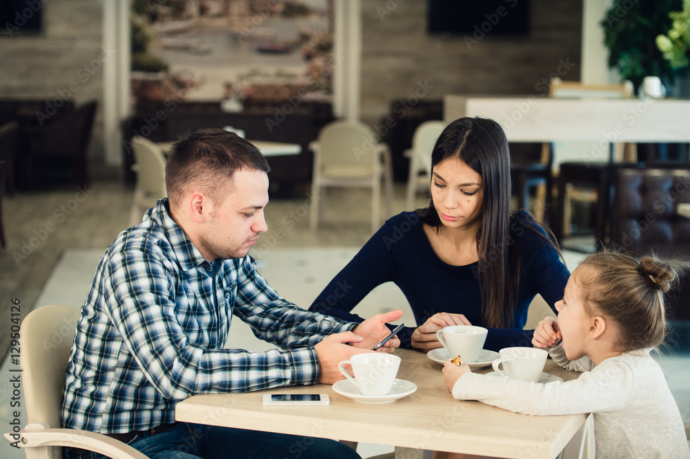 Family Enjoying tea In Cafe Together