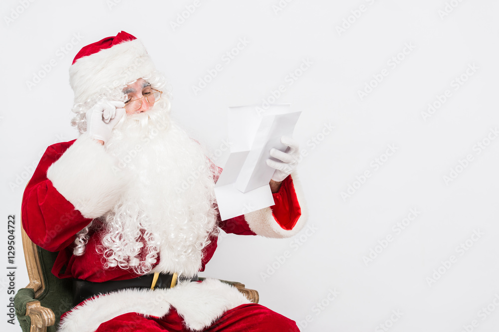 Fototapeta premium Santa Claus Reading Letter isolated over white baclground