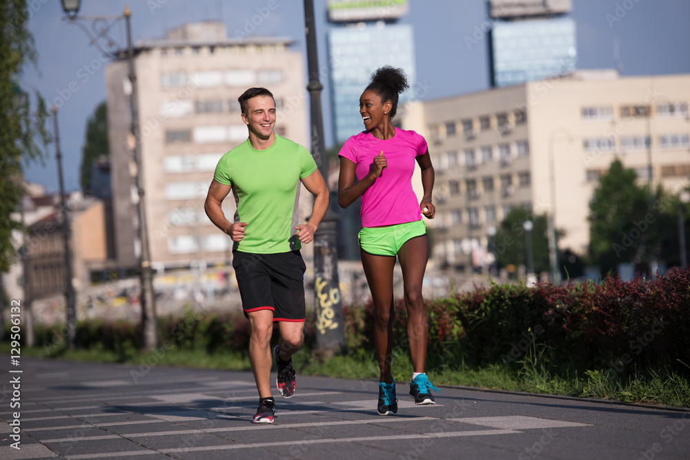 young smiling multiethnic couple jogging in the city