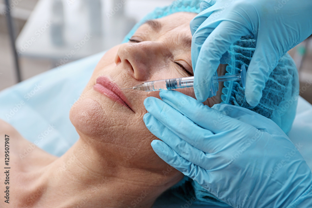 Senior woman having hyaluronic acid injection at beauty salon Senior woman having hyaluronic acid injection at beauty salon