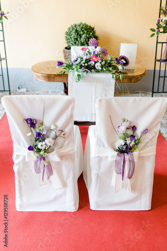 Stühle vor Pfarrer bei einer Trauung mit Blumen geschmückt