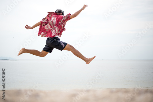 Athletic young man enjoying the summer, jumping in a tropical beach © freebird7977
