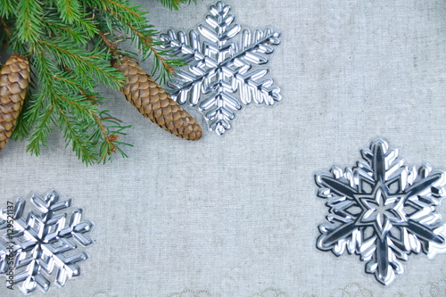новогодняя композиция еловые ветки,шишки,снежинки на фоне льняной ткани