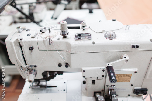 Coverstitch sewing machine close-up. Fashion designer equipment in tailor workshop. Industrial, occupation, clothes making concept