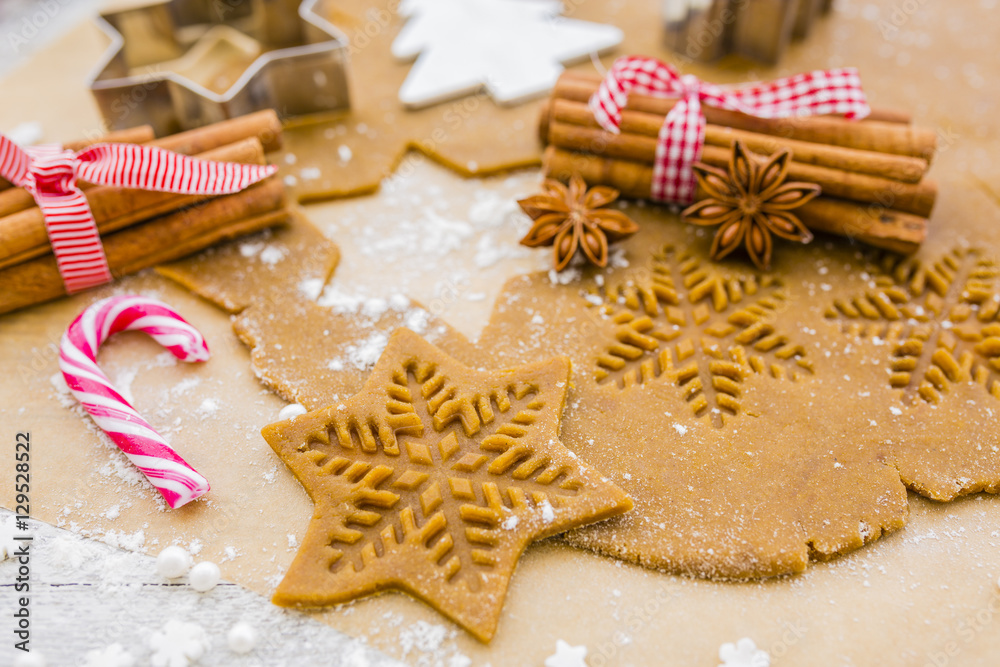 Christmas homemade gingerbreads and Christmas spices on a wooden background.
