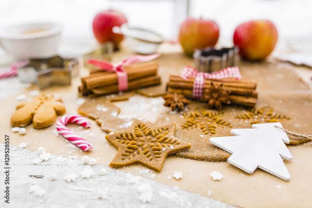Christmas homemade gingerbreads and Christmas spices on a wooden background.
