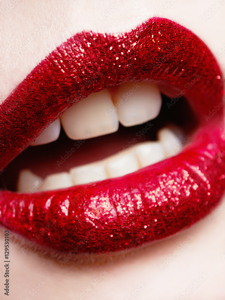 Obraz premium beautiful red lips with glitter.event make-up.part of woman face