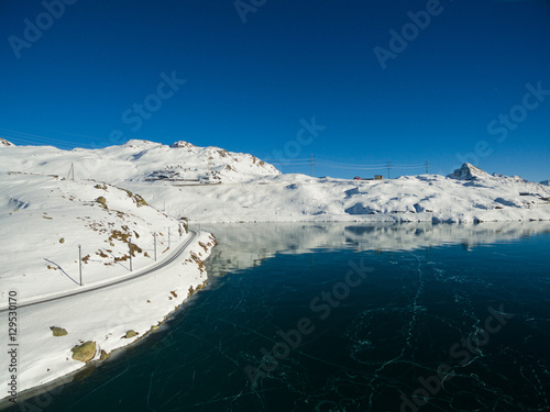 Passo del Bernina - Lago ghiacciato e trenino rosso photo