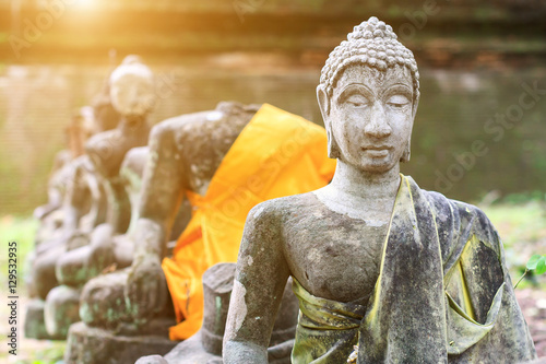 Old ruined buddha statue with sunlight background in Wat Umong temple, Chiang Mai, Travel in northern Thailand. photo