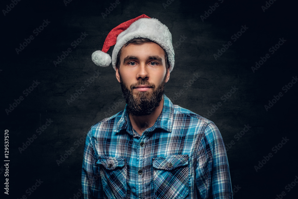 Portrait of bearded male dressed in a plaid shirt and Santa's ha Portrait of bearded male dressed in a plaid shirt and Santa's ha