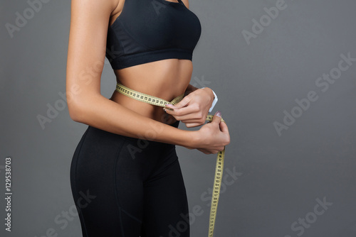 Cuadro en lienzo Close up of woman measuring her waist