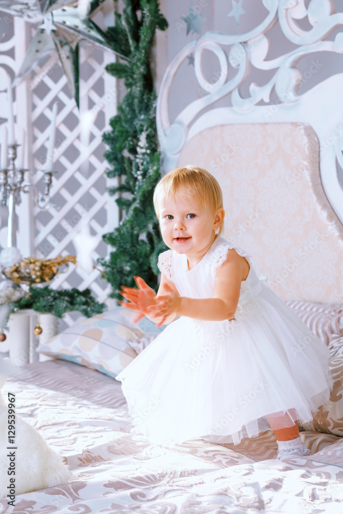 happy little girl in white dress standing in the Christmas decorated room happy little girl in white dress standing in the Christmas decorated room