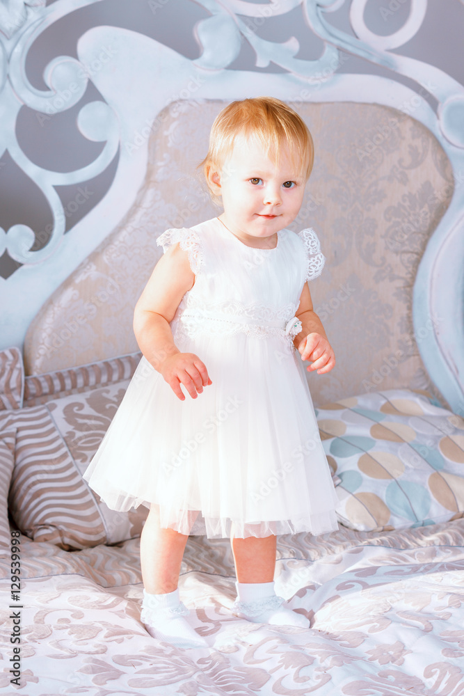 happy little girl in white dress standing in the Christmas decorated room happy little girl in white dress standing in the Christmas decorated room
