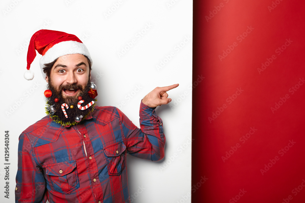 long bearded man in santa claus hat pointing away long bearded man in santa claus hat pointing away