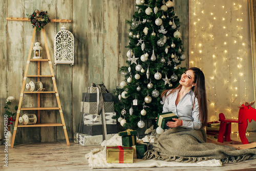 Beautiful brunette girl is opens the gift at Christmas © newagecinema