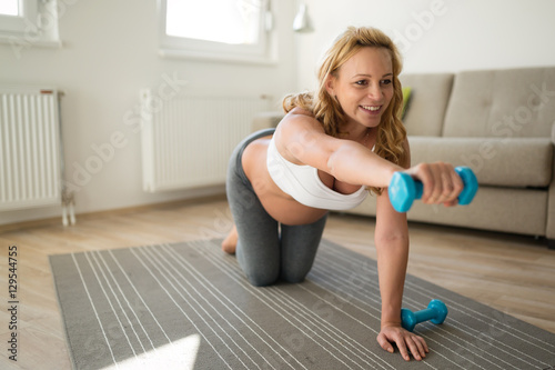 Pregnant woman training with dumbbells