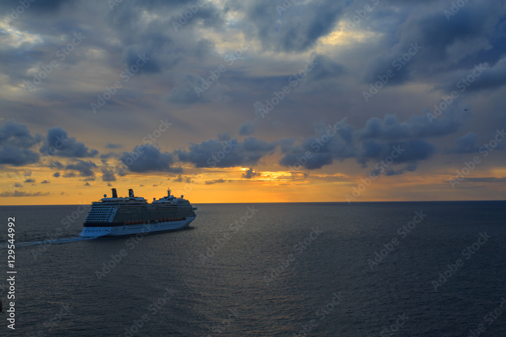 Cruise ship sailing on ocean during the sunset.