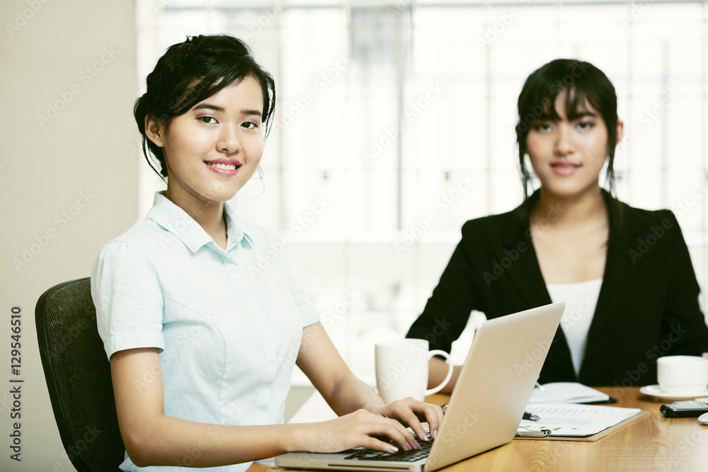 Beautiful young businesswomen working and typing