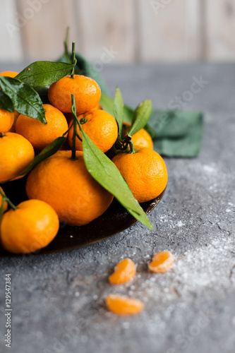 orange tangerines in a bowl on light background